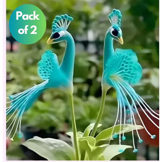 Two blue peacock figurines with a 'Pack of 2' label on a blurred green background.